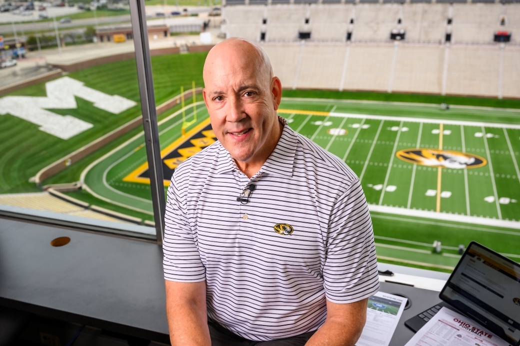 Man standing in a sports stadium box suite.