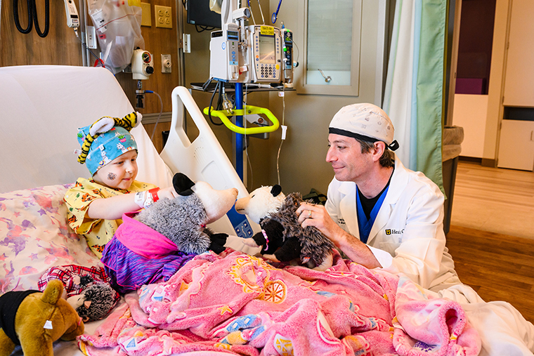 Sophie Bergen and Thomas Willson, MD, play with her stuffed opossum family during a visit to Children’s Hospital in Columbia.