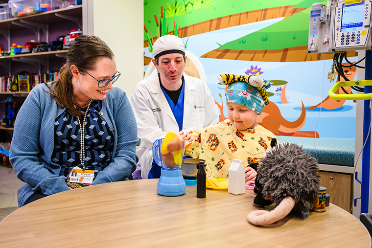 Sophie Bergen cooks for Trash Queen, Cecilia Belzarena, MD, and Thomas Willson, MD, in the playroom of Children’s Hospital in Columbia.