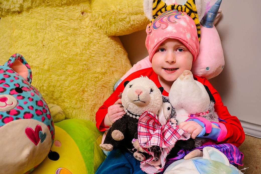 A photo of a child with stuffed animals.