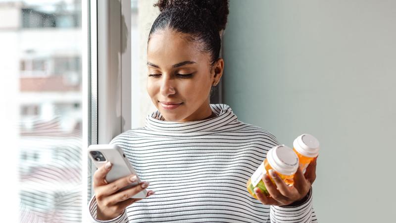 This is an image of a woman holding a bottle of pills.