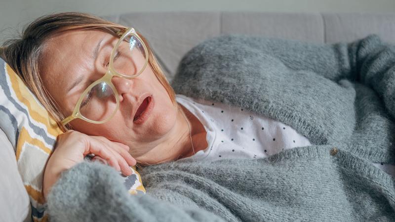 A photo of a woman asleep on the couch.