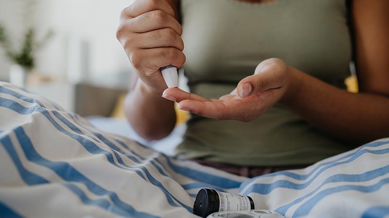 female doing a fingerstick blood test