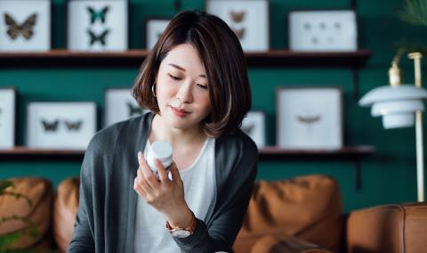 woman looking at pill bottle