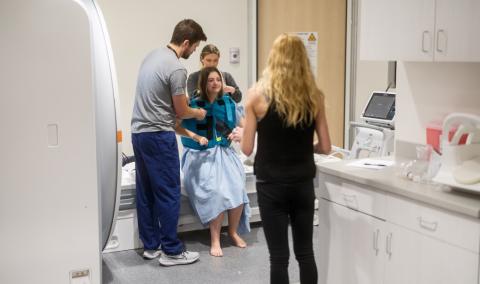 Health care workers helping a female patient.