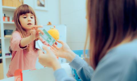 A mother and child playing toy money.