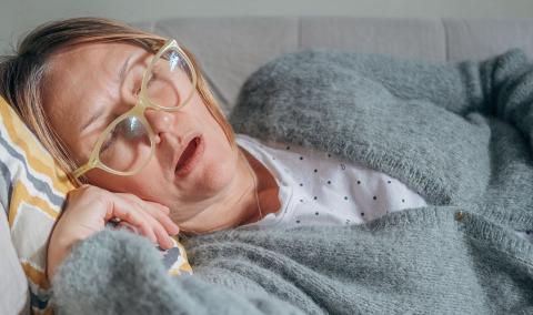 A photo of a woman asleep on the couch.