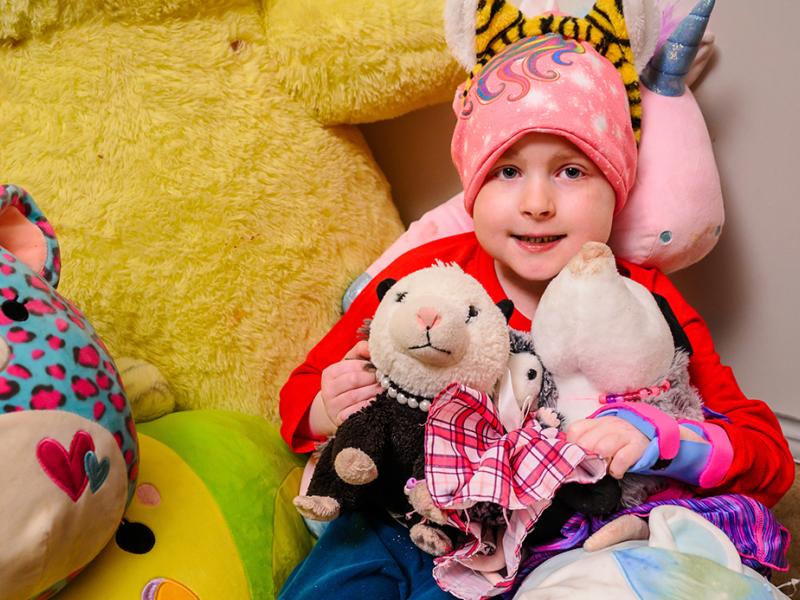 A photo of a child with stuffed animals.