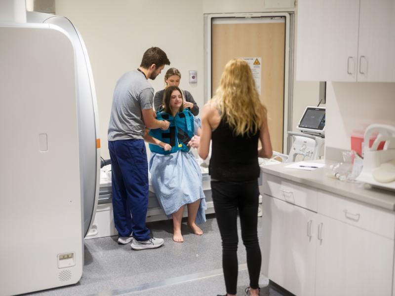 Health care workers helping a female patient.